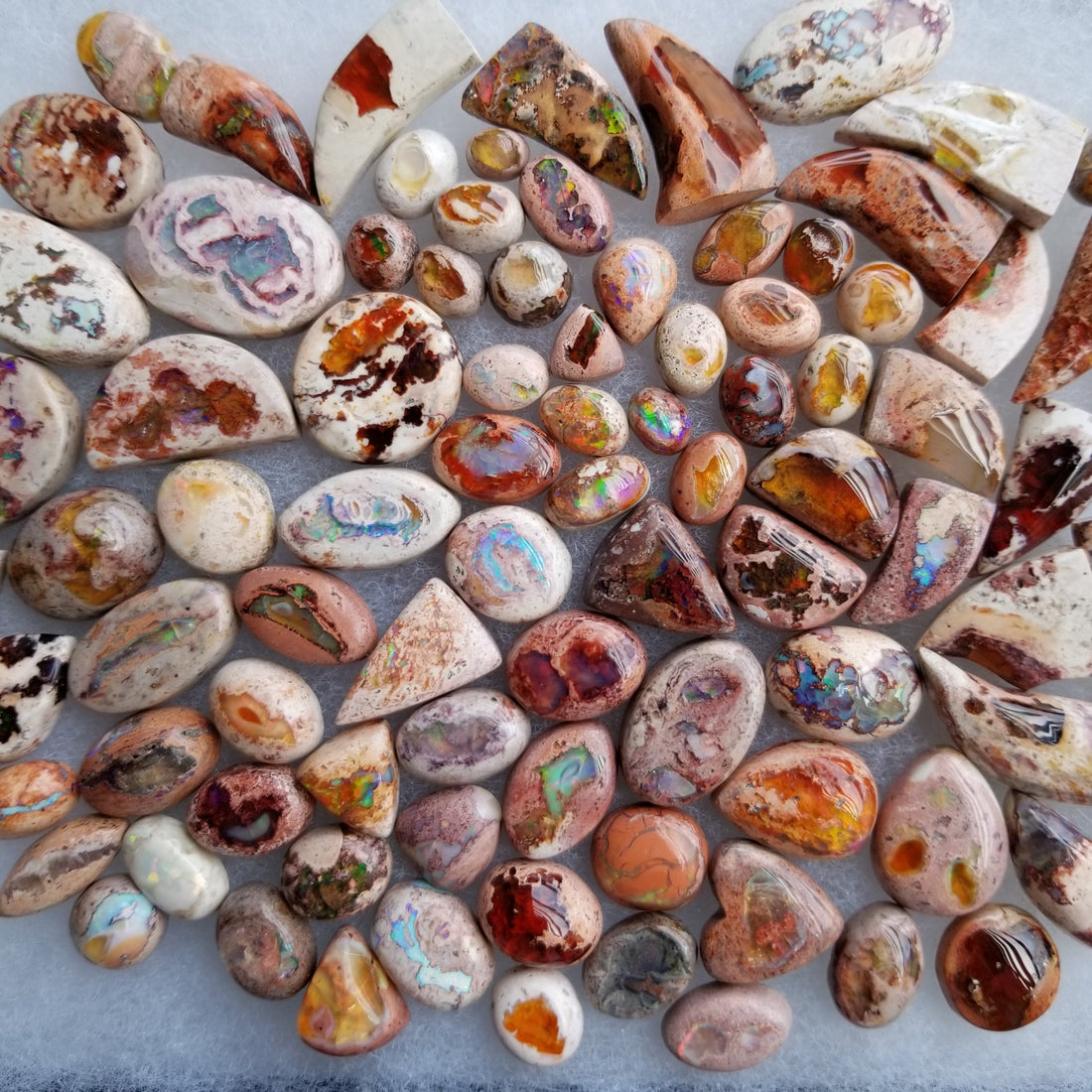 Cantera opal cabochons showing play-of-color in volcanic matrix